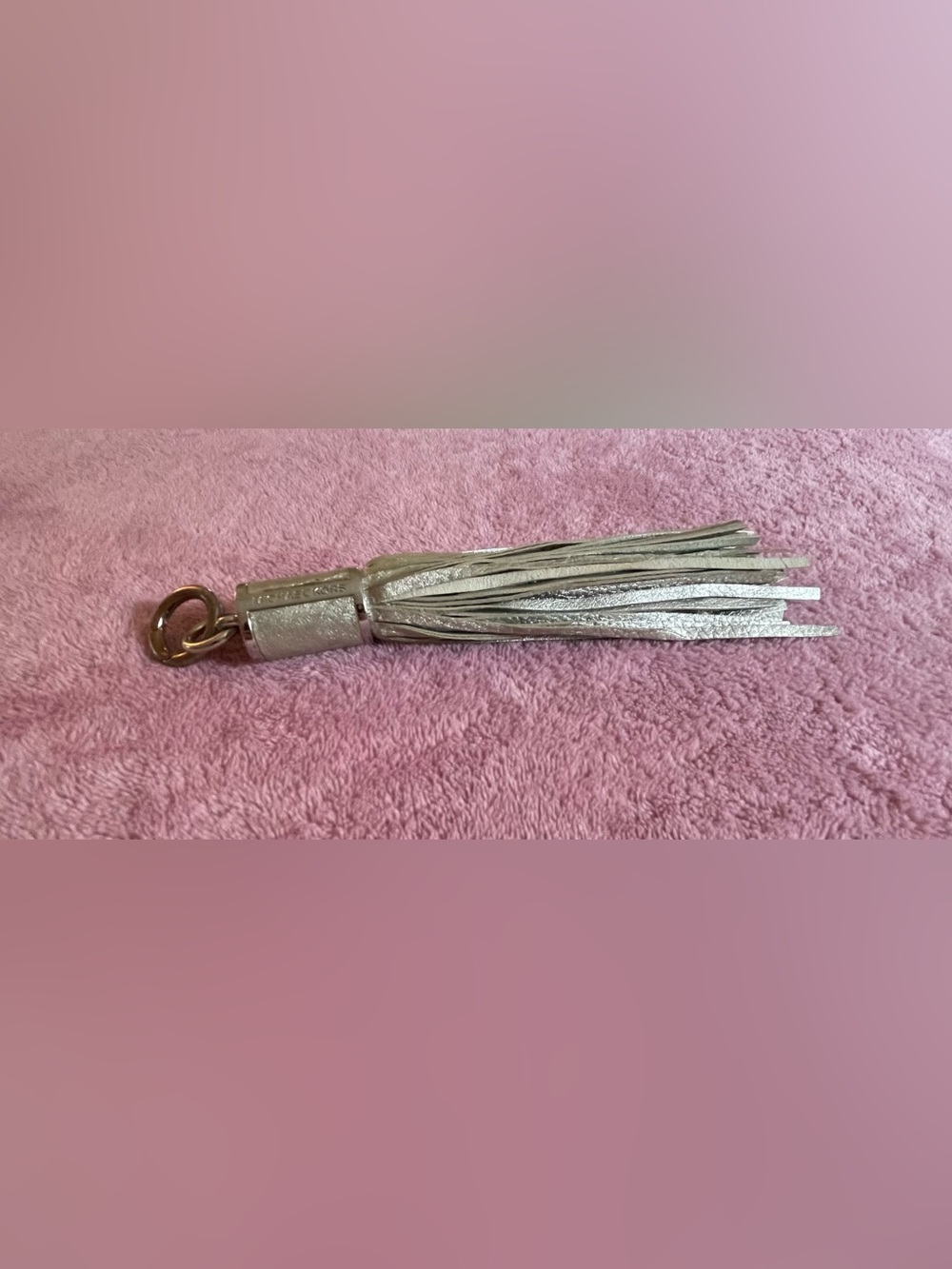 Michael Kors silver bag charm with metallic leather finished fringe and tassel